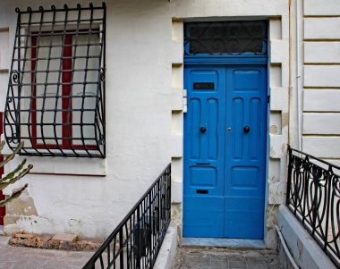 Malta 'da Sliema' da bir evin eski mavi ön kapısı ve parmaklıklı penceresi.