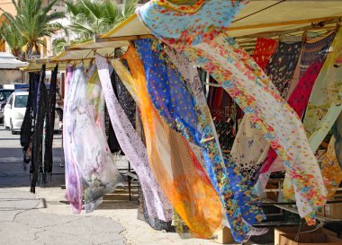 Marsaxlokk, Malta 'da bir market tezgahında rüzgarda uçuşan çok renkli ipek eşarplar.