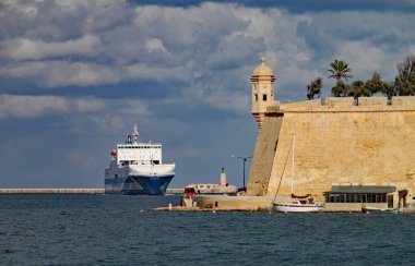 VALLETTA, MALTA - 14 Kasım 2019: Valletta limanına bir kargo gemisi giriyor