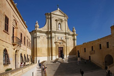 VICTORIA, GoZO, MALTA - 15 Ekim 2019: insanlar katedralin basamaklarından çıkıyorlar. 1697 ve 1711 yılları arasında bir Roma tapınağının sahasında inşa edildi.