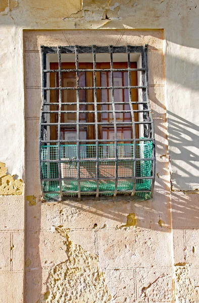 Old rusty grill fixed to a window in an old building in Valletta, Malta