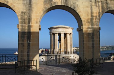 BARRAKKA GARDENS, VALLETTA, MALTA - 16 Kasım 2019: kemer yoluyla görülen Kuşatma Çanı Savaşı Anıtı. İkinci Dünya Savaşı sırasında Malta halkının cesaretini anmak için 1992 'de inşa edildi.