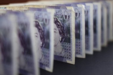 EXETER, ENGLAND - 20 ARALIK 2019: 20 poundluk banknotlar siyah bir arkaplanda duruyor. Sadece ortadaki nota keskin bir odak noktasında.