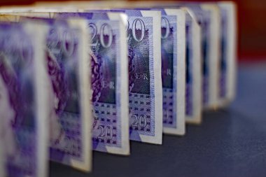 EXETER, ENGLAND - 20 ARALIK 2019: 20 poundluk banknotlar siyah bir arkaplanda duruyor. Sadece ortadaki nota keskin bir odak noktasında.