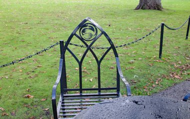 Süslü ve kemer şekilli siyah metal sandalye.