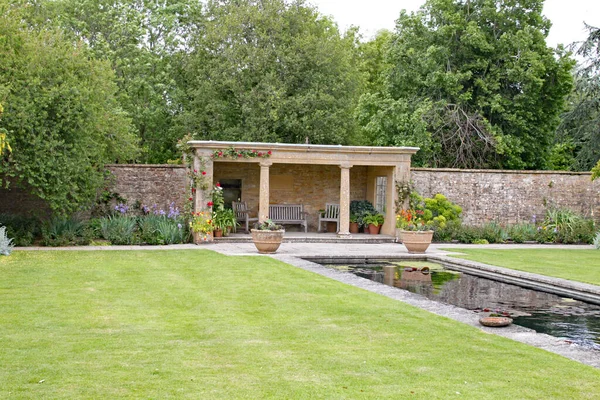 英国乡村花园的一个观赏性池塘覆盖的座位区 — 图库照片