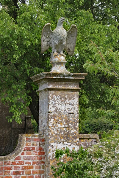 一只石鹰在正方形的立柱上守卫着一座英国乡间别墅 — 图库照片