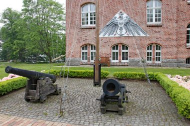 Alman Donanma Akademisi 'nde bayrak direğinin yanında iki top.