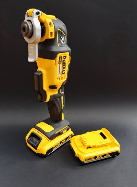 OTTERY St. Mary, DEVON - 6 Şubat 2020: Dewalt Kablosuz Çoklu Araç siyah arka planda bataryası üzerinde dimdik duruyor. Yedek batarya yan tarafta..