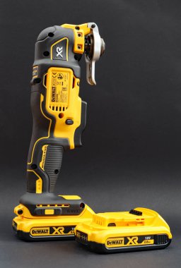 OTTERY St. Mary, DEVON - 6 Şubat 2020: Dewalt Kablosuz Çoklu Araç siyah arka planda bataryası üzerinde dimdik duruyor. Yedek batarya yan tarafta..