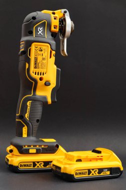 OTTERY St. Mary, DEVON - 6 Şubat 2020: Dewalt Kablosuz Çoklu Araç siyah arka planda bataryası üzerinde dimdik duruyor. Yedek batarya yan tarafta..