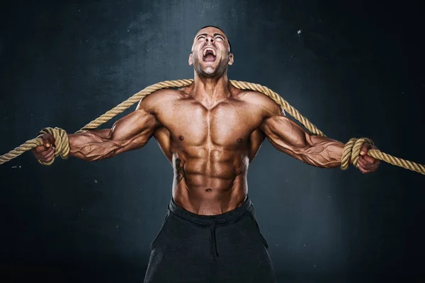 Hombres musculares fuertes atrapados en cuerdas tratando de frenar perder. Culturista atrapado en cuerdas —  Fotos de Stock