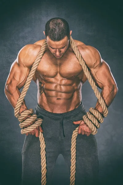 Güçlü kas erkekler halatlar içinde sıkışıp fren çalışırken kaybetmek. Halatlar içinde sıkışmış bodybuilder — Stok fotoğraf