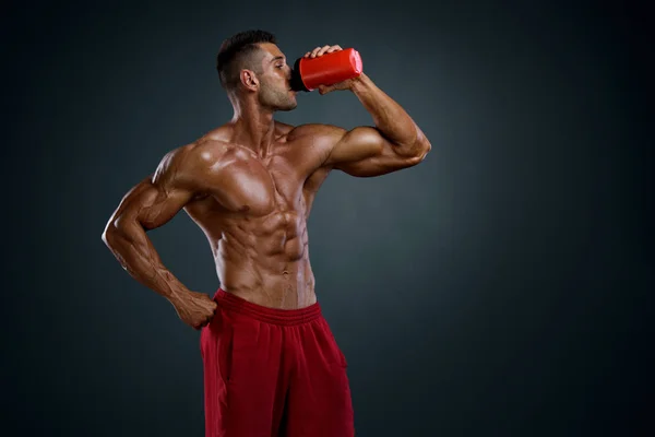 Los hombres musculares beben batido de proteína, bebida energética —  Fotos de Stock