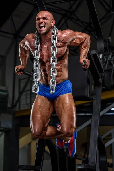 Vücut geliştirmeci onun ne etrafında ağır zincir Ile spor salonunda dips yapıyor — Stok fotoğraf