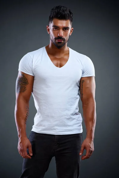 Modelo masculino atractivo de la aptitud que usa los pantalones vaqueros y las camisetas blancas — Foto de Stock