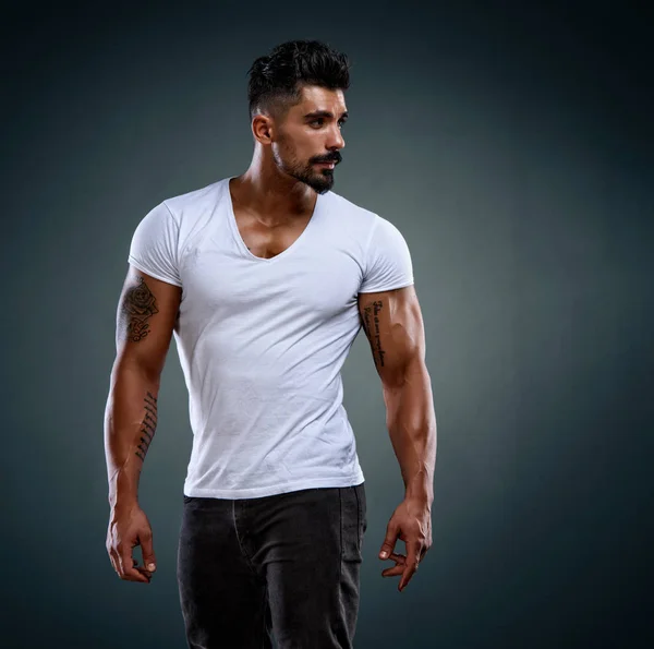 Modelo masculino atractivo de la aptitud que usa los pantalones vaqueros y las camisetas blancas — Foto de Stock