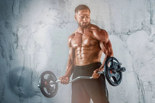 Mięśni mężczyźni ćwiczenia z ciężarkami. On wykonuje E-Z bar biceps loki — Zdjęcie stockowe
