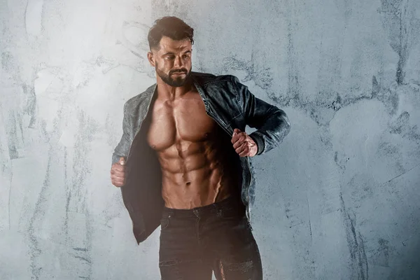 Hombres musculosos en pantalones vaqueros usando chaqueta pero exponiendo su torso muscular —  Fotos de Stock