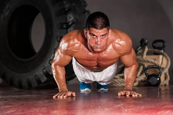 Yakışıklı kaslı adam spor salonunda şınav yapıyor — Stok fotoğraf