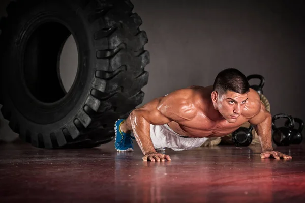 Przystojny muskularny Człowiek robi pompki w siłowni — Zdjęcie stockowe