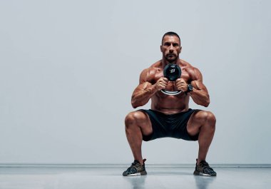 Yakışıklı kaslı, Çapraz Eğitimli Kettlebell ile Çömelme Yapan Sporcu