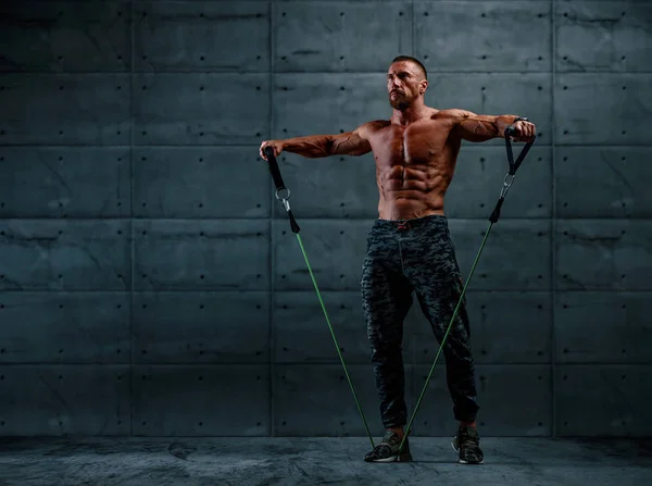 Ejercicio muscular atlético para hombres con banda de resistencia. Copiar espacio — Foto de Stock