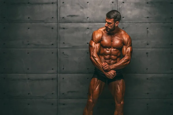 Stattliche, sehr muskulöse Männer, die die Muskeln spielen lassen. Bodybuilder posiert und lässt Muskeln spielen — Stockfoto