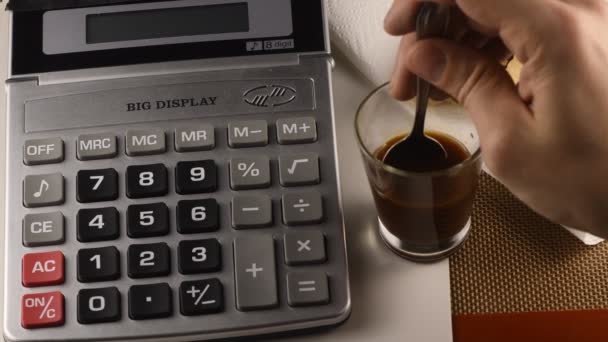 Άνθρωπος Χρησιμοποιώντας Αριθμομηχανή Και Ποτό Καφέ — Αρχείο Βίντεο