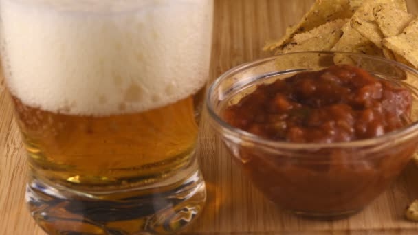 テーブルの上にチップとビールのグラスのためのホットトマトソース — ストック動画