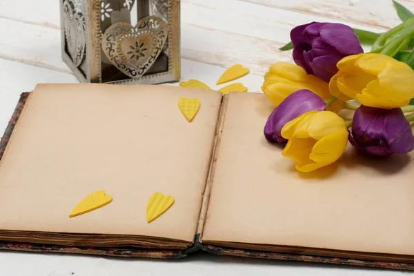 一个概念浪漫 旧笔记本和郁金香在木桌上 — 图库照片