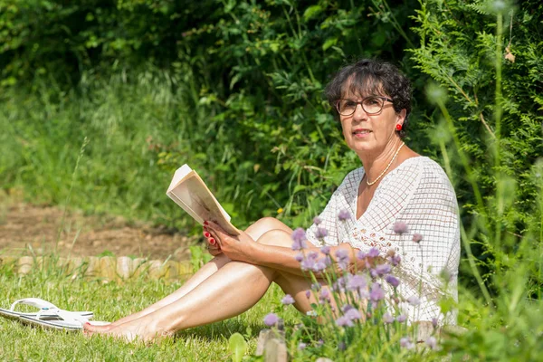 Güzel Bir Üst Düzey Kadın Bahçede Bir Kitap Okuma — Stok fotoğraf