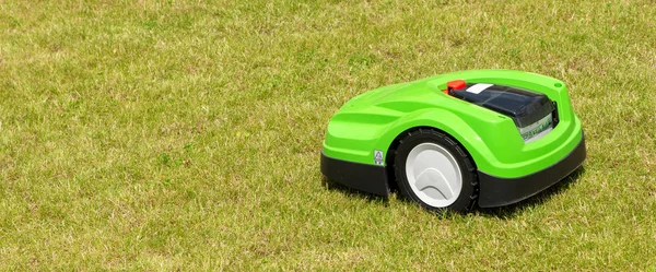 a green robot lawn mower on the lawn