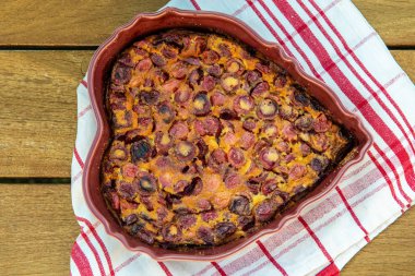 Kiraz ahşap bir masa üzerinde kalp şeklinde ile bir clafouti