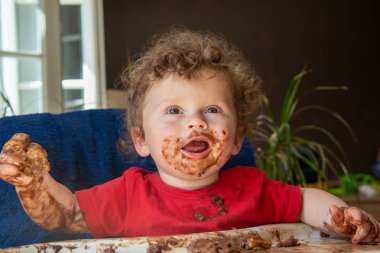 bir bebek bir çikolatalı kek yiyor