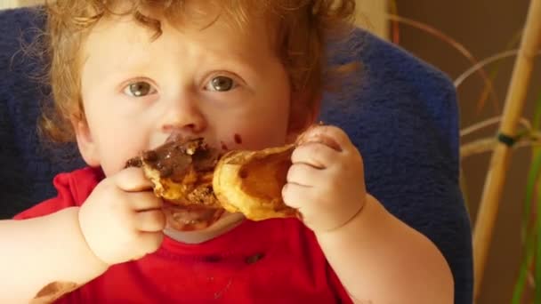 幸せな赤ちゃんは チョコレート ケーキを食べています — ストック動画