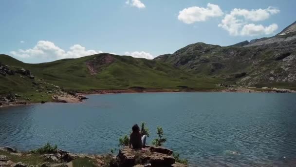 妇女徒步旅行者看 Estaens 湖在比利牛斯山脉山 — 图库视频影像