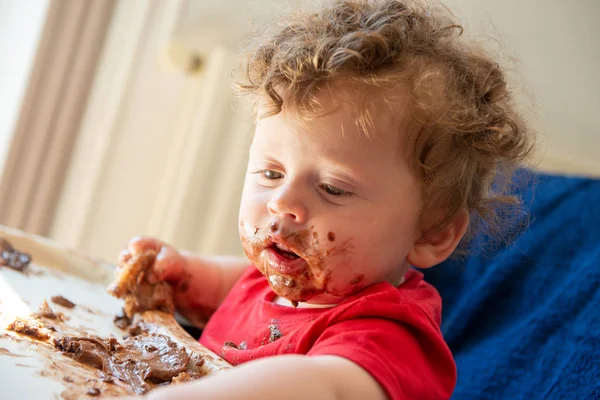 bir bebek bir çikolatalı kek yiyor