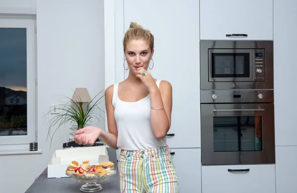 Una Guapa Joven Rubia Comiendo Pasteles Cocina —  Fotos de Stock