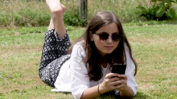 Adolescente Couchée Dans Herbe Utilise Smartphone — Video