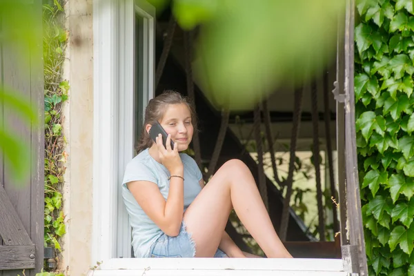 Дівчина Підліток Сидить Біля Вікна Використовує Смартфон — стокове фото