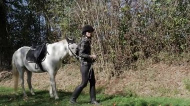 Genç kadın binici beyaz atı ile