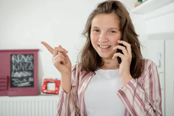 Mutfakta Bir Akıllı Telefon Kullanan Bir Genç Kız — Stok fotoğraf