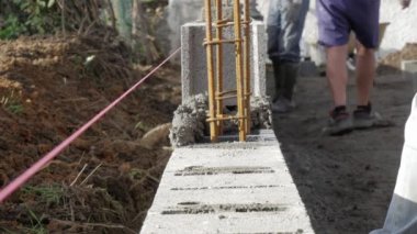 Duvarcı beton blok ve beton ile bir duvar inşa