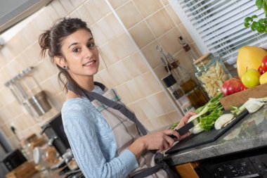 Genç ve güzel bir esmer kadın mutfakta yemek