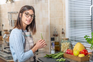 Genç ve güzel bir esmer kadın mutfakta yemek