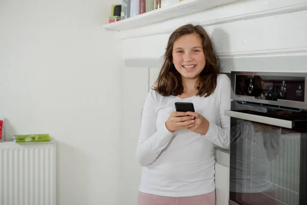 Mutfakta Bir Akıllı Telefon Kullanan Genç Kız — Stok fotoğraf