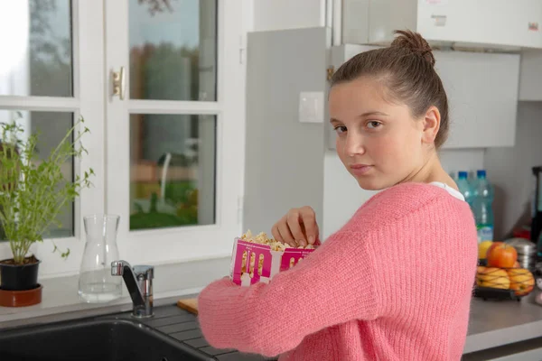 Jong Tiener Meisje Met Een Roze Trui Popcorn Eten Thuis — Stockfoto