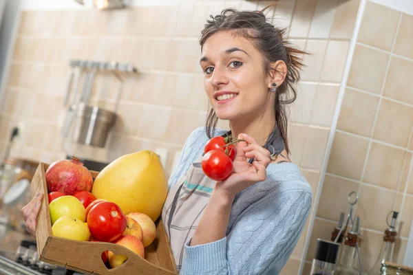 微笑的年轻女子与各种水果在厨房 — 图库照片