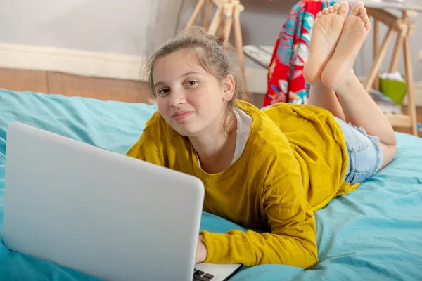 Sorrindo Adolescente Deitada Cama Usando Laptop — Fotografia de Stock